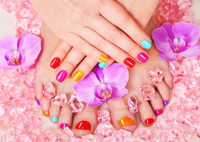 Colorful vibrant pedicure with pink orchids and crystals